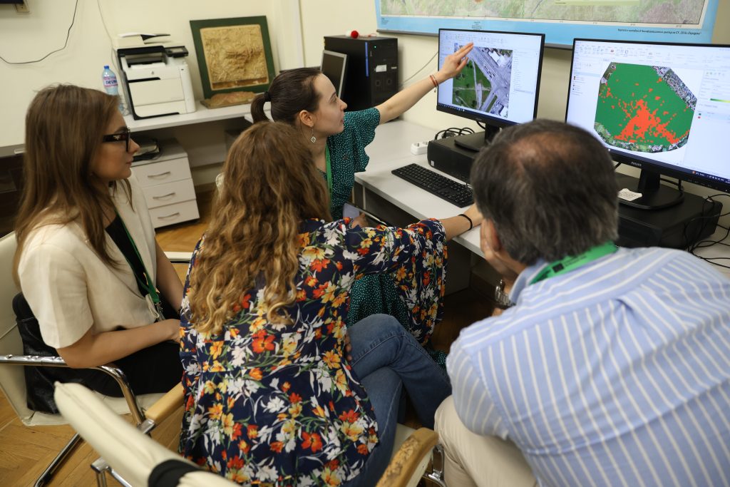 Four people discussing something visible on a computer screen