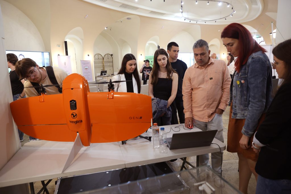 People looking at a drone on exhibition