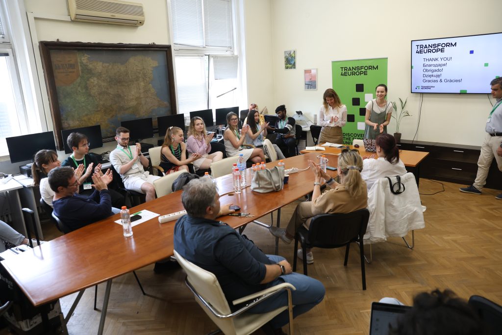 A group of people sitting at a long conference table