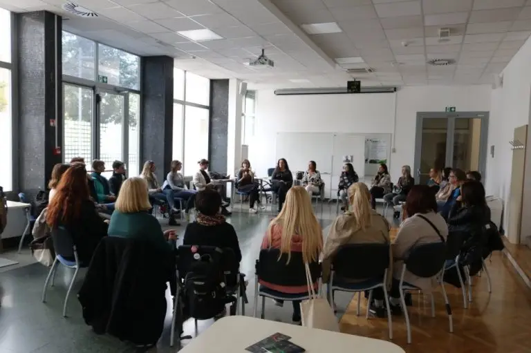 A group of people sit in a large circle in a bright, modern room, participating in a discussion or meeting. Most are women, and the room has large windows letting in natural light. Photo: University of Primorska