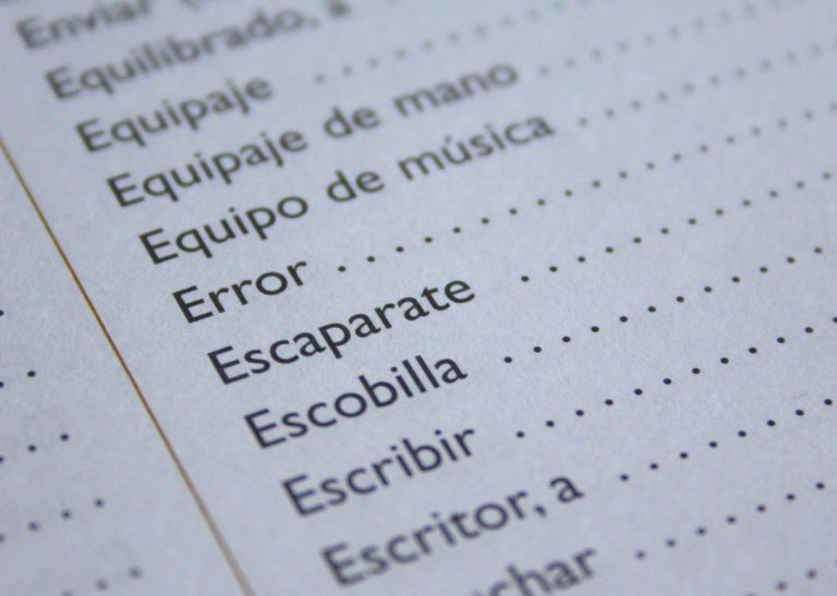 A close-up of a dictionary page showing Spanish words such as “Error,” “Escaparate,” “Escobilla,” and “Escribir,” each followed by dotted lines, with some words partially visible at the top.