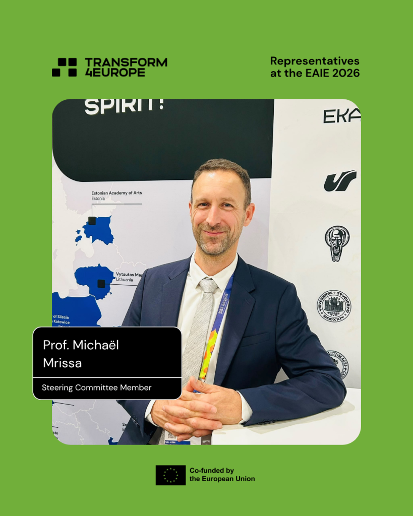 A man in a suit sits in front of a map display at an event booth. Text on the image reads Prof. Michaël Mrissa, Steering Committee Member. Transform4Europe and EU logos are visible.