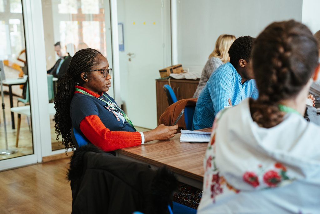 A group of people attending a meeting or class around a wooden table.